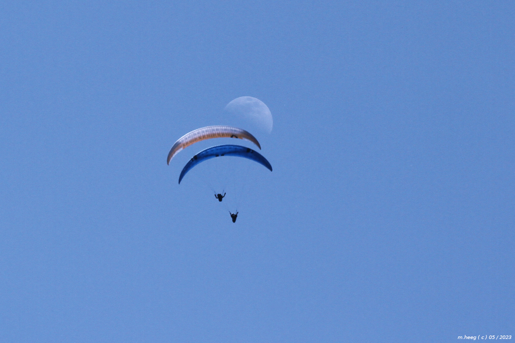 Tagesmond und Gleitschirmflieger